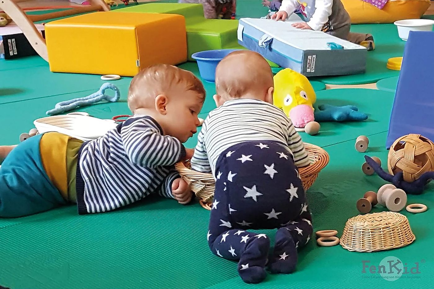 Kinder spielen gemeinsam auf einer Krabbeldecke